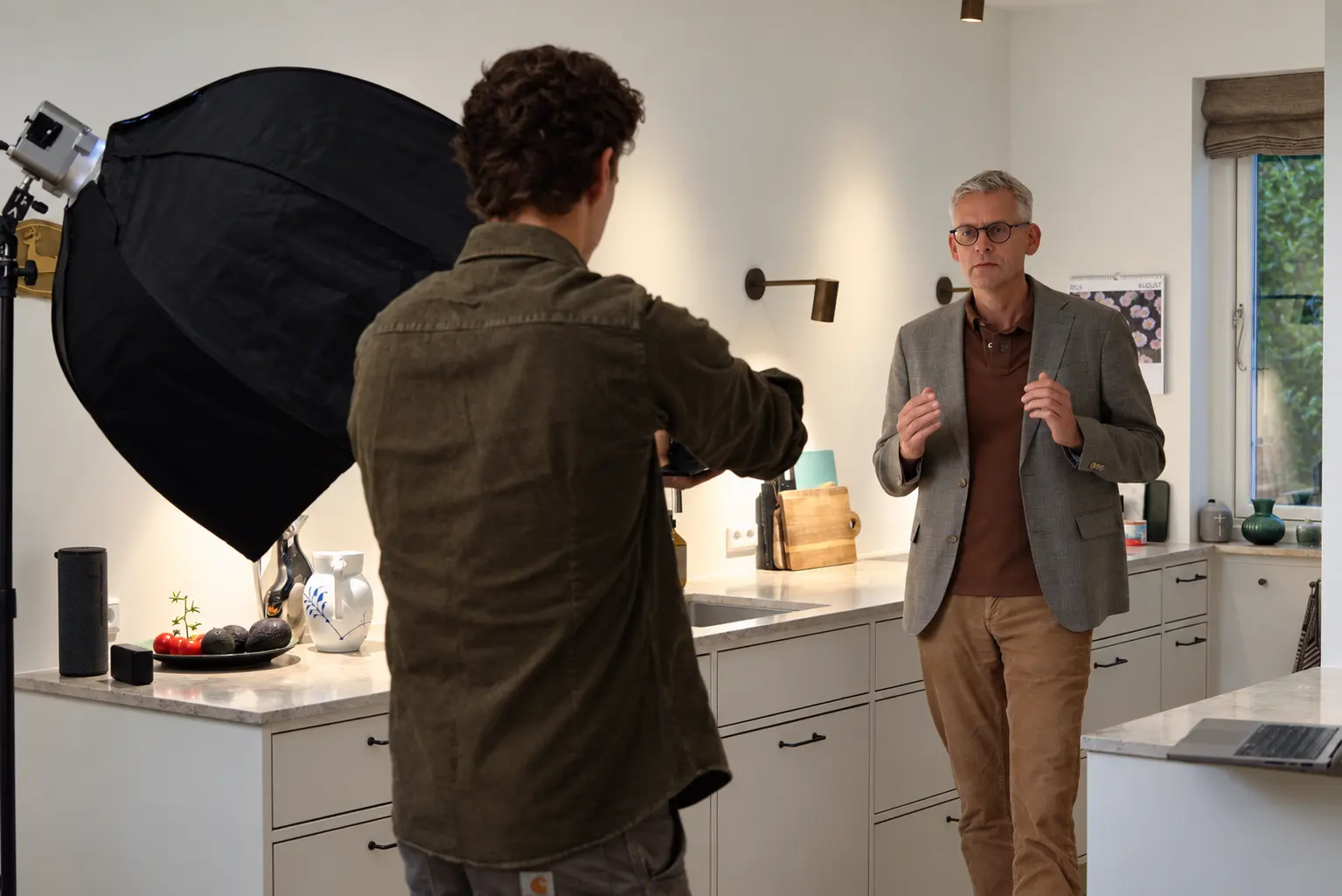 Niels fra Ravn Productions filmer en kunde i et køkken med softbox-opsætning